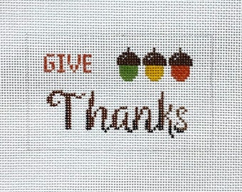 May include: Give Thanks with three acorns in brown, green, and orange colors.