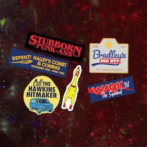 Könnte beinhalten: Eine Sammlung bunter Aufkleber mit verschiedenen Designs und Texten. Aufkleber enthalten "Stubborn Punk-Ass", "Repent! Halley's Comet is Coming", "Bradley's Big Buy", "Call the Hawkins Hitmaker", ein gelbes Huhn und "WSOK The Squawk".