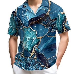 Puede incluir: Camisa de manga corta con un llamativo diseño abstracto de mármol azul y dorado. La camisa presenta un cuello clásico y un corte relajado. El patrón incluye tonos de azul y dorado, creando un aspecto único y llamativo.