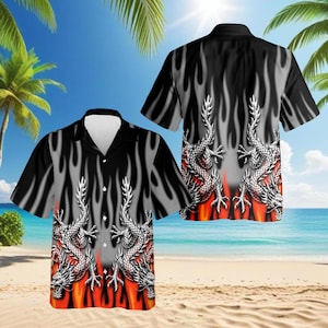 May include: Black short-sleeve button-down shirt with a dragon and flame design. The shirt features a white collar and a pattern of silver dragons set against a backdrop of gray flames and red accents.