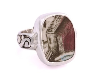 May include: A silver ring with a square-shaped setting featuring a vintage ceramic tile with a black and white image of a building with a red roof.