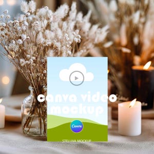 Puede incluir: Una plantilla de maqueta digital rectangular que presenta un cielo azul claro con un icono de nube blanca, un símbolo de botón de reproducción y un gráfico de paisaje verde en la parte inferior. El texto canva video mockup y el logo de Canva están centrados.