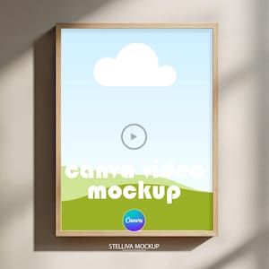 Puede incluir: Un marco de madera rectangular vertical que contiene un gráfico digital de un cielo azul claro con una nube blanca sobre una colina verde. El centro presenta un icono de reproducción circular y el texto canva video mockup.