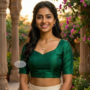 May include: A woman wearing a green blouse with short sleeves and a sweetheart neckline, paired with a cream-colored skirt adorned with gold embroidery. The image includes the text "AStitchDesign".
