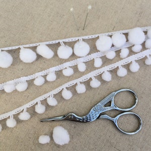 Witte pomponband. Kerstknutsel.  Mini-pom pom rand.