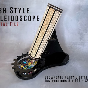 Puede incluir: Un caleidoscopio de madera con un diseño geométrico en blanco y negro. El caleidoscopio está sobre un soporte negro con una base en forma de engranaje. La base tiene una ventana transparente que muestra cuentas de colores en el interior. El texto "DISH STYLE KALEIDOSCOPE DIGITAL FILE" está en la parte superior de la imagen. El texto "GLOWFORGE READY DIGITAL FILES INSTRUCTIONS & A PDF + SVG" está en la parte inferior de la imagen.