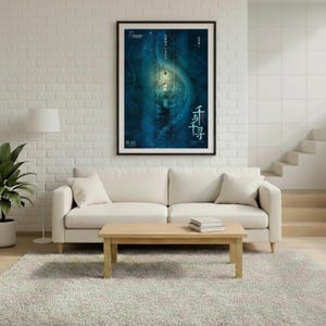May include: A living room scene featuring a cream-colored sofa, a wooden coffee table, and a large framed poster with blue and white artwork. A potted plant and a floor lamp are also present. The room has a neutral color palette with a light gray rug.