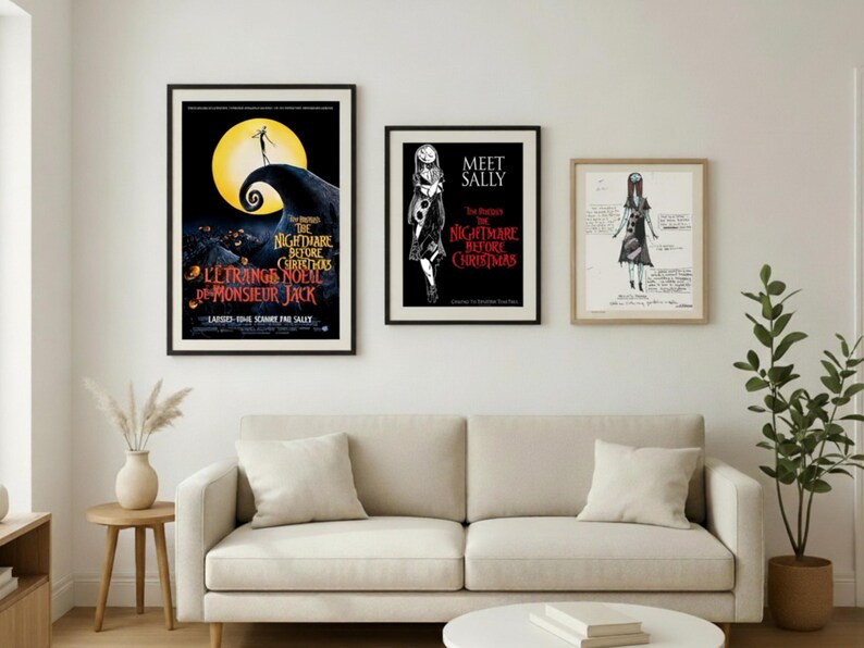 May include: Three framed posters featuring artwork from "The Nightmare Before Christmas" movie. The posters are displayed above a beige sofa. The first poster has the movie title in English and French. The second poster says "Meet Sally". The third poster is a sketch.