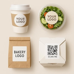 Op de afbeelding: Vogelperspectief van vier voedselcontainers. Een witte koffiebeker met een bruine hoes en een sticker met de tekst "YOUR LOGO". Een doorzichtige plastic bak met salade en een sticker met de tekst "YOUR LOGO". Een bruine papieren zak met een sticker met de tekst "BAKERY LOGO". Een witte doos met een QR-code en een sticker met de tekst "SCAN ME".