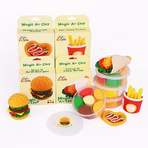 May include: A collection of Magic Air Clay food sets, including a burger, pizza, fries, and a wrap. The sets come in boxes with the text "Magic Air Clay" and "Glue N Scissors". The clay food items are colorful and detailed.