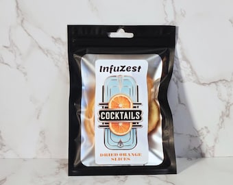May include: A black resealable bag containing a clear package of dried orange slices. The clear package has a label with the text "InfuZest" above a graphic of an orange slice and the word "COCKTAILS". The text "DRIED ORANGE SLICES" is below the graphic.