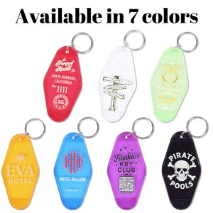 May include: Seven colorful motel-style keychains with silver key rings. Each keychain features unique designs and text, including "EVA HOTEL", "The Perfect Mater", "Frankie's Key Club", and "PIRATE POOLS". The text "Available in 7 colors" is at the top.