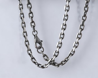 May include: A silver-toned chain necklace with an oval link design. The necklace features a lobster clasp closure. The chain is displayed against a white background.