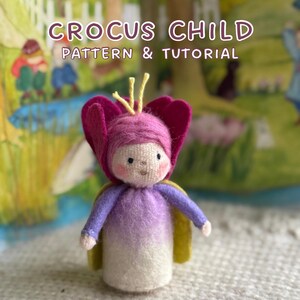 Könnte beinhalten: Eine handgefertigte Filzpuppe in Form eines Krokus-Kindes, mit einem rosa blütenförmigen Hut und einem lila-weißen Körper. Die Puppe hat einen gelben Umhang und der Text "CROCUS CHILD PATTERN & TUTORIAL" ist sichtbar.