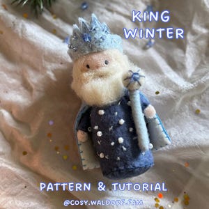 Op de afbeelding: Een vilten King Winter pop met een lichtblauwe kroon, baard en cape. De pop draagt een donkerblauwe tuniek met witte stippen en houdt een staf vast. De tekst "KING WINTER" en "PATTERN & TUTORIAL" is zichtbaar.