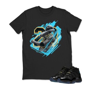 May include: Black t-shirt featuring a graphic of a basketball player in a blue and gold design, with the number 23. A pair of black and blue sneakers are at the bottom of the image.