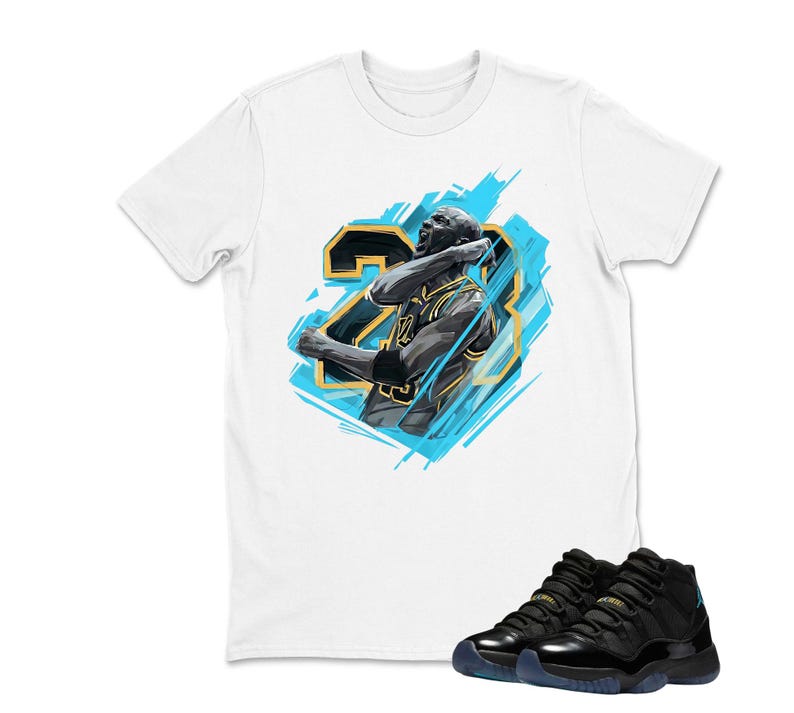 May include: White t-shirt featuring a graphic of a basketball player with the number 23, in black and gold, with a blue background. Black and blue sneakers are in the foreground.