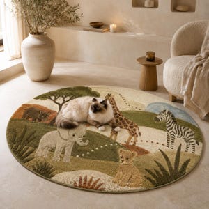 Round wool area rug hand-tufted with a safari scene of giraffes, zebras, an elephant, and acacia trees on a green and tan landscape.