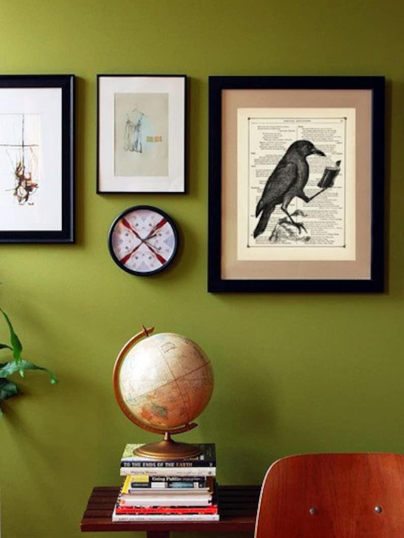 May include: A black and white illustration of a crow reading a book, framed in a black frame and hanging on a green wall. A globe, clock, and other framed artwork are also visible.