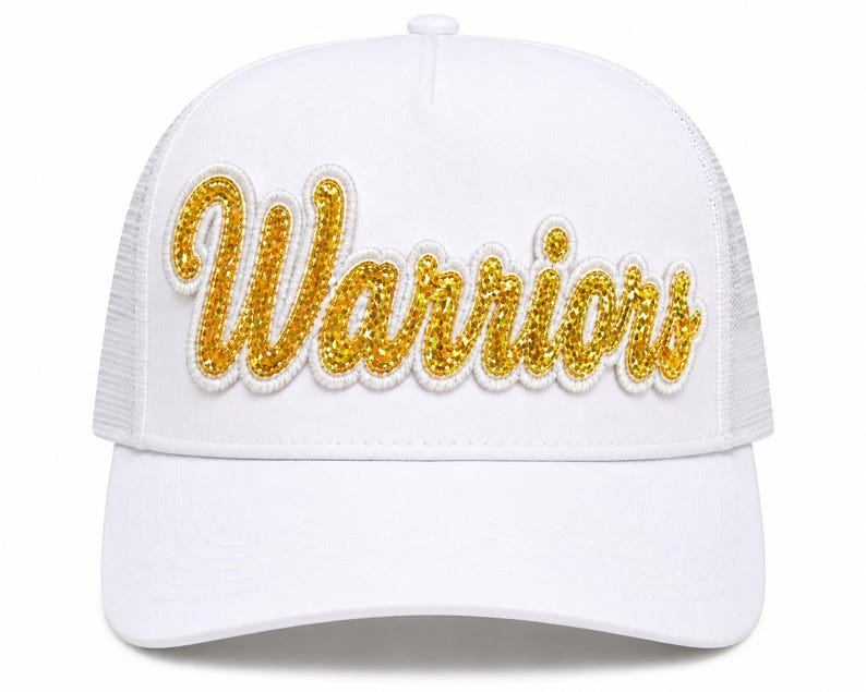 May include: A white trucker hat featuring the word Warriors in gold glitter script lettering across the front panel. The cap has a structured front, a curved brim, and a mesh back section. The gold text is outlined in white embroidery.