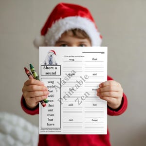 May include: A spelling worksheet featuring a polar bear graphic and the text "Short a sound" is held by a person. The worksheet includes words such as "wag," "apple," and "fast." Two crayons, one red and one green, are held in the person's other hand.