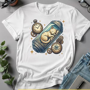 May include: White t-shirt featuring a whimsical illustration of a sleeping cat inside a glass container, surrounded by pocket watches and gears. The design has a steampunk aesthetic with gold and blue accents. The shirt is paired with blue jeans and a notebook.