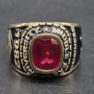 May include: A white ceramic mug with a black handle and the text "But First, Coffee" in a black, bold font. The mug is on a white surface.