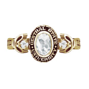 Puede incluir: Un anillo dorado con una piedra grande y transparente de forma ovalada en el centro. El anillo presenta las palabras "CENTRAL STATE UNIVERSITY" en un óvalo marrón oscuro. Pequeñas piedras transparentes están engastadas a ambos lados de la piedra central.