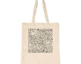 May include: Cream-colored tote bag with black doodle art. The design features various whimsical elements, including stars, hearts, and an alien spaceship. The bag has a rectangular shape with a square design in the center and long handles.