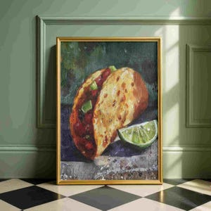 May include: A framed oil painting of a taco with a lime wedge. The taco has a golden-brown shell, filled with red and green ingredients. The lime is bright green. The painting is in a gold frame, leaning against a green wall.