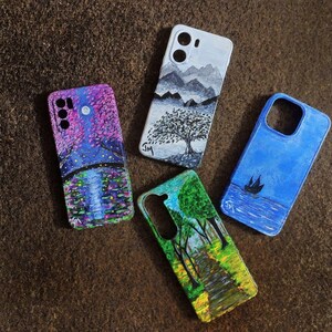 May include: Four hand-painted phone cases with landscape designs. One case features a purple and blue night scene with a bridge. Another has a black and white mountain and tree design. A third is blue with a boat, and the last has a path through trees.