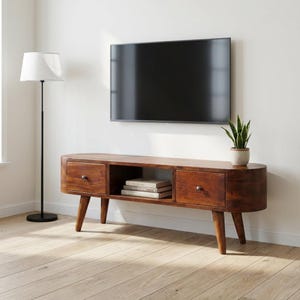 May include: A wooden TV stand in a mid-century modern style, featuring two drawers and an open shelf. The stand is a warm brown colour, with rounded edges and tapered legs. A flat-screen TV is mounted above the stand.