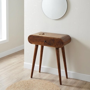May include: A brown wooden console table with a single drawer and four tapered legs. The table features a smooth, rounded rectangular top and a small, dark metal knob on the drawer front. A set of metal keys rests on the top surface.