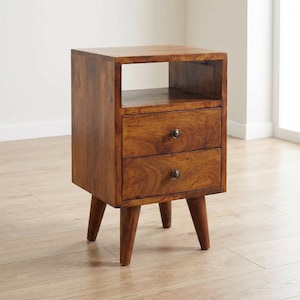May include: A wooden nightstand with two drawers and a top shelf. The nightstand is made of a warm-toned wood and has a mid-century modern design. The drawers have round, dark knobs and the nightstand is supported by angled legs.