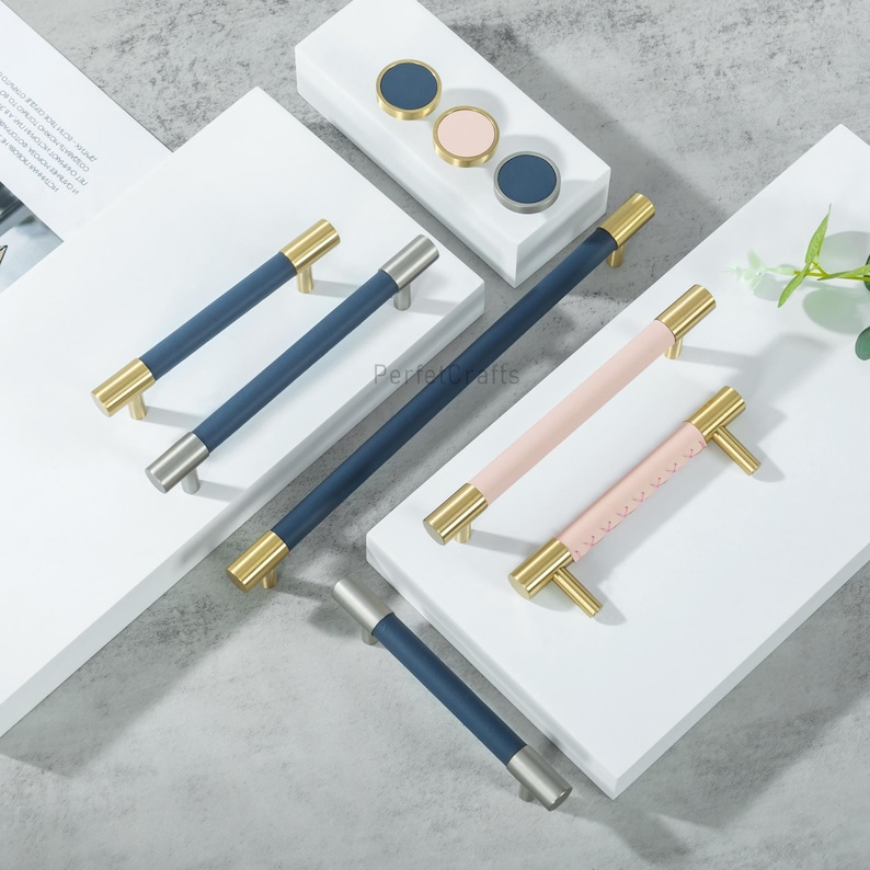 Puede incluir: Un conjunto de herrajes para armarios, que incluye tiradores en azul marino y rosa con detalles dorados y plateados. La imagen tambi&eacute;n muestra pomos redondos a juego en azul marino y rosa.