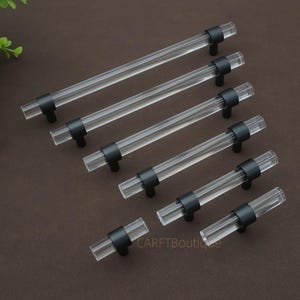 May include: A set of three ceramic mugs with a speckled, matte finish in cream, light grey, and dark grey. Each mug has a simple, modern design and a rounded handle. The mugs are stacked on top of each other.