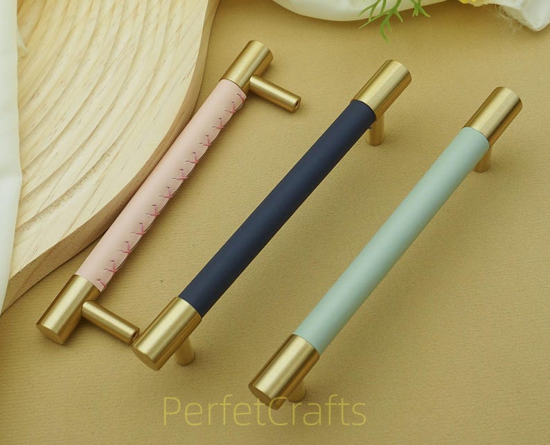 Puede incluir: Tres tiradores de armario con herrajes de lat&oacute;n y secciones centrales de colores. Los tiradores tienen un centro rosa, azul marino y azul claro. El texto "PerfetcCrafts" es visible en la esquina inferior derecha.