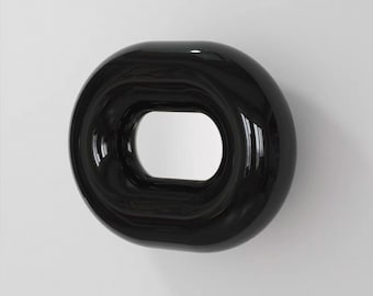 May include: A glossy black wall mirror with a rounded rectangular frame. The frame has a thick, smooth, and reflective surface that curves inward toward the central rectangular glass mirror pane, creating a deep, dimensional, and bold appearance.