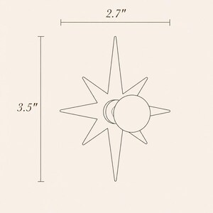 May include: A star-shaped wall hook with a circular knob center. The design features eight pointed rays of varying lengths. Dimension lines indicate a width of 2.7 inches and a height of 3.5 inches, providing clear scale for the object.