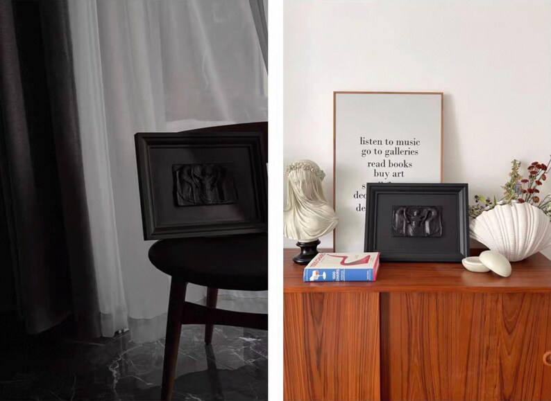K&ouml;nnte beinhalten: Zwei schwarz gerahmte Reliefskulpturen, eine auf einem Stuhl und eine auf einem Holzschrank. Die Skulpturen zeigen Figuren im klassischen Stil. Ein gerahmter Druck mit Text und eine B&uuml;ste sind ebenfalls zu sehen.