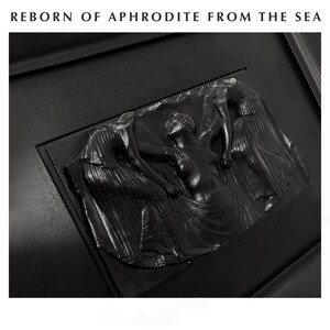 K&ouml;nnte beinhalten: Schwarze Reliefskulptur mit drei Figuren in flie&szlig;enden Gew&auml;ndern und dem Text "REBORN OF APHRODITE FROM THE SEA" oben. Die mittlere Figur hebt die Arme. Die Skulptur ist in einen dunklen Rahmen gesetzt, was einen dramatischen Kontrast erzeugt.