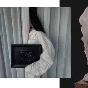K&ouml;nnte beinhalten: Eine schwarz gerahmte Reliefskulptur wird vor einem wei&szlig;en Vorhang gehalten. Das Relief scheint eine dunkle, monochrome Darstellung von Figuren zu sein. Die Person, die den Rahmen h&auml;lt, tr&auml;gt ein wei&szlig;es Hemd.