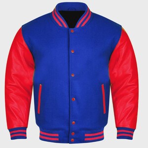 Könnte beinhalten: Blaue Collegejacke mit roten Lederärmeln. Die Jacke hat einen gerippten Kragen, Bündchen und Saum mit roten und weißen Streifen. Sie hat eine Knopfleiste und zwei Vordertaschen mit roter Einfassung.