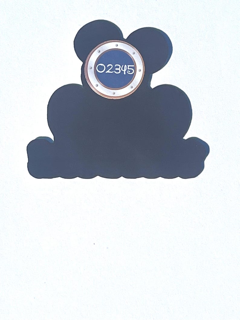 Puede incluir: Un letrero decorativo azul oscuro con la forma de la cabeza de Mickey Mouse. Tiene un elemento circular con el n&uacute;mero "02345" en blanco. El letrero est&aacute; sobre un fondo blanco.