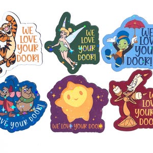 May include: Six holographic stickers featuring animated characters including Tigger, Tinker Bell, Jiminy Cricket, two mice, a star-shaped creature, and Lumiere. Each sticker displays the text WE LOVE YOUR DOOR! in various colors and fonts.