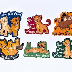 May include: A set of six stickers featuring characters from The Lion King, including Simba, Nala, Timon, and Pumbaa. Each sticker displays the text "We Love Your Door!" and incorporates colorful, holographic accents against various background colors.