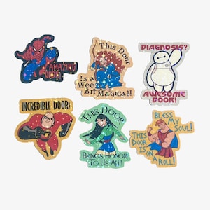 May include: A set of six holographic stickers featuring various animated characters. The stickers include Spider-Man with text 'Amazing Door!', Merida with 'This Door Is a Wee Bit Magical!', Baymax with 'Diagnosis? Awesome Door!', Mr. Incredible with 'Incredible Door!', Mulan with 'This Door Brings Honor To Us All!', and Hercules with 'Bless My Soul! This Door Is On A Roll!'