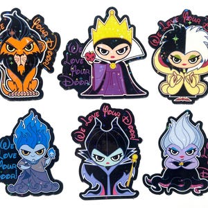 Puede incluir: Conjunto de seis pegatinas de villanos de Disney. Cada pegatina presenta un personaje diferente, incluyendo a Scar, la Reina Malvada, Cruella de Vil, Hades, Mal&eacute;fica y &Uacute;rsula. Las pegatinas tienen el texto "We Love Your Door!" en una fuente decorativa.