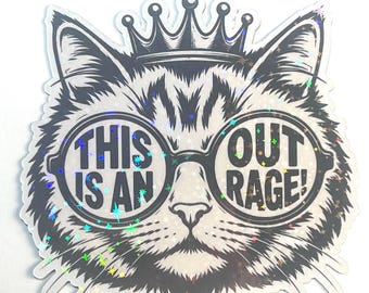 May include: A holographic sticker featuring a black and white illustration of a cat wearing a crown and round glasses. The text "THIS IS AN OUTRAGE!" is printed inside the lenses of the glasses. The sticker has a reflective, shimmering finish.