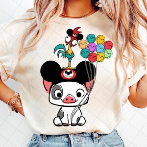May include: Cream-colored t-shirt featuring a cartoon illustration of a pig wearing Mickey Mouse ears and holding colorful balloons. A rooster stands on top of the pig's head. The design includes the text "Mickey Mouse Club".